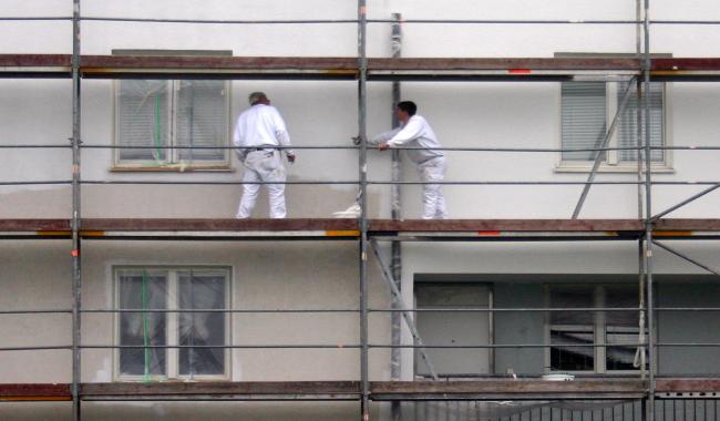 Workers painting exterior of apartment