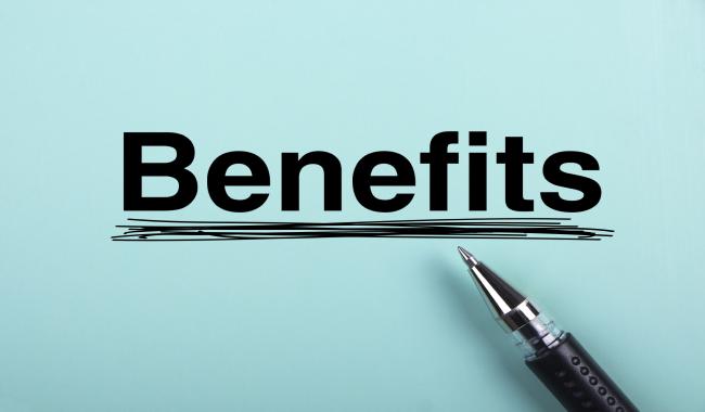 a pen points to the word benefits written and underlined on a blue paper