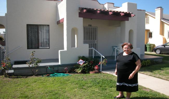 A woman standing in front of an affordable single-family home.