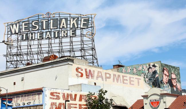 A building with swap meet on it and a West Lake theatre sign