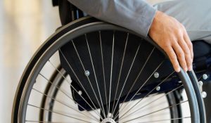 An image of hand on wheel of a wheelchair