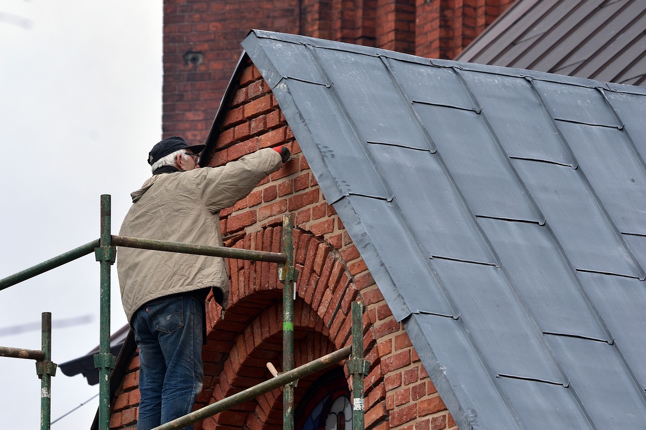 man doing renovation on outside of house